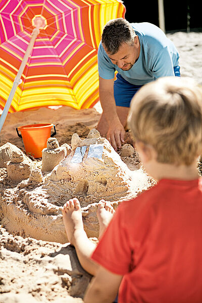 Vater und Kind bauen Sandburg
