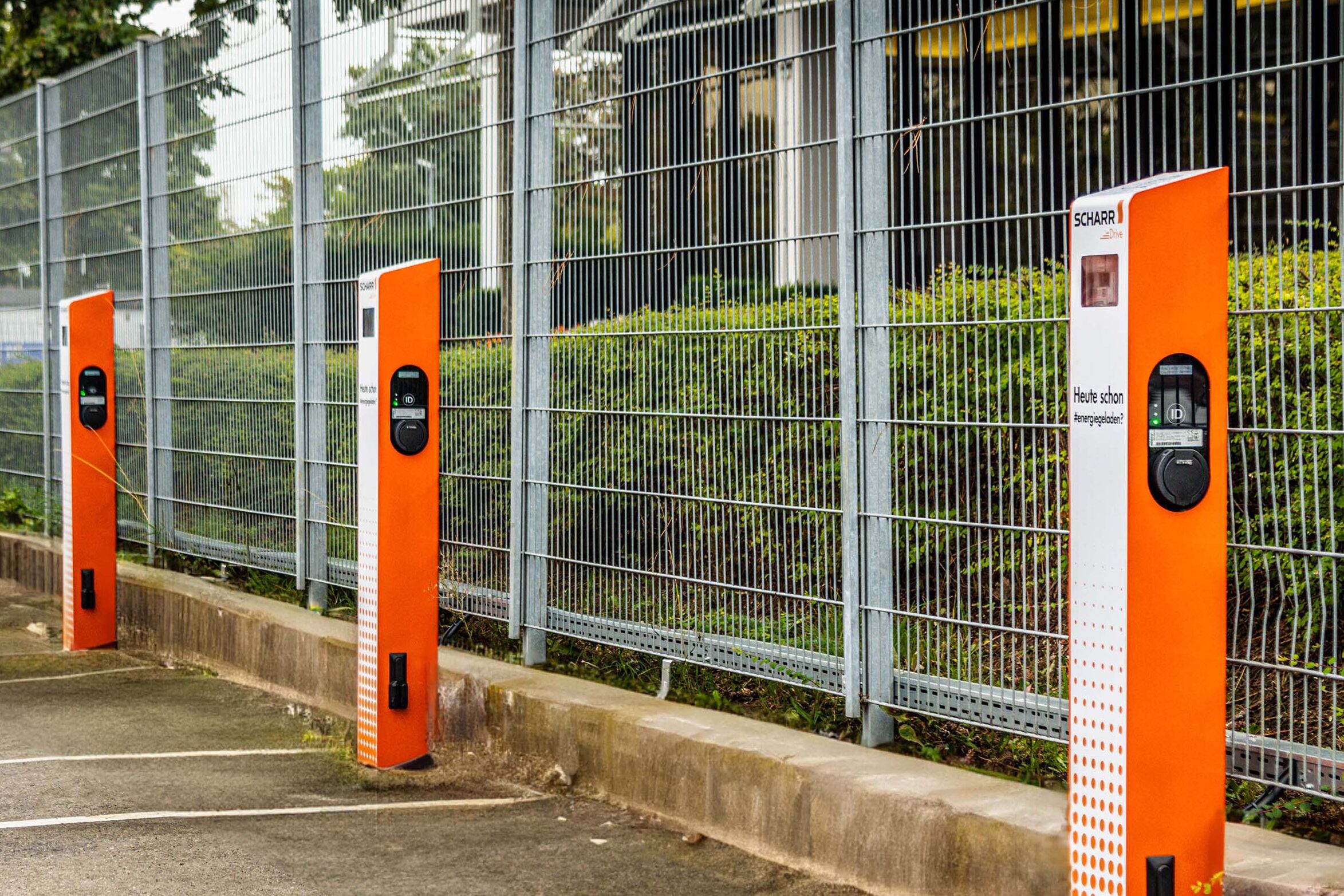 Firmenparkplatz mit orangenfarbenen Ladesäulen für E-Autos
